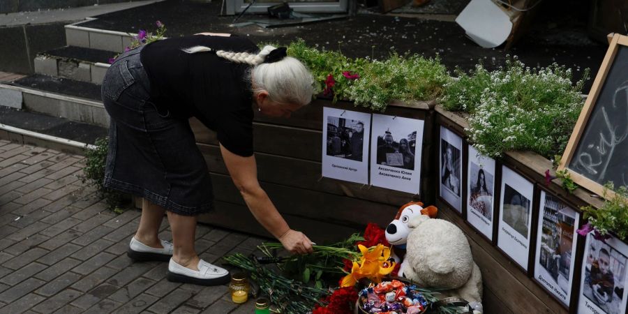 Eine Anwohnerin legt Blumen vor dem Restaurant in Kramatorsk ab, das durch einen russischen Angriff zerstört wurde.