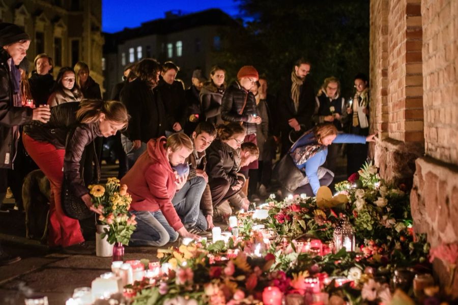 Menschen trauern vor der Synagoge in Halle (D). Dort hat ein Antisemit im Oktober 2019 eine Person erschossen.