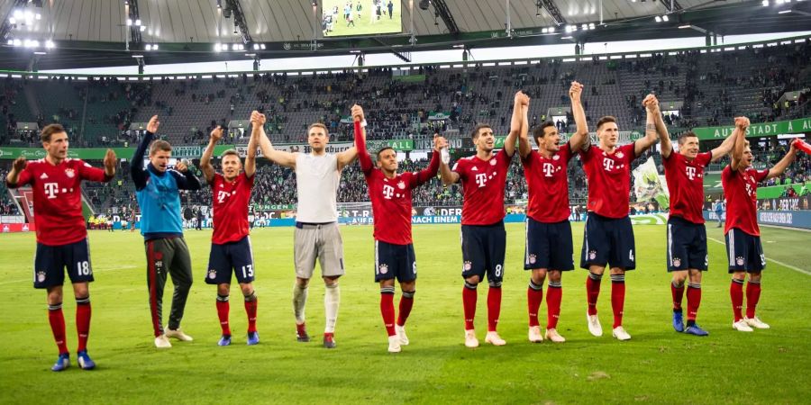 Bayern Münchens Spieler stehen nach dem Spiel auf dem Feld und lassen sich feiern.