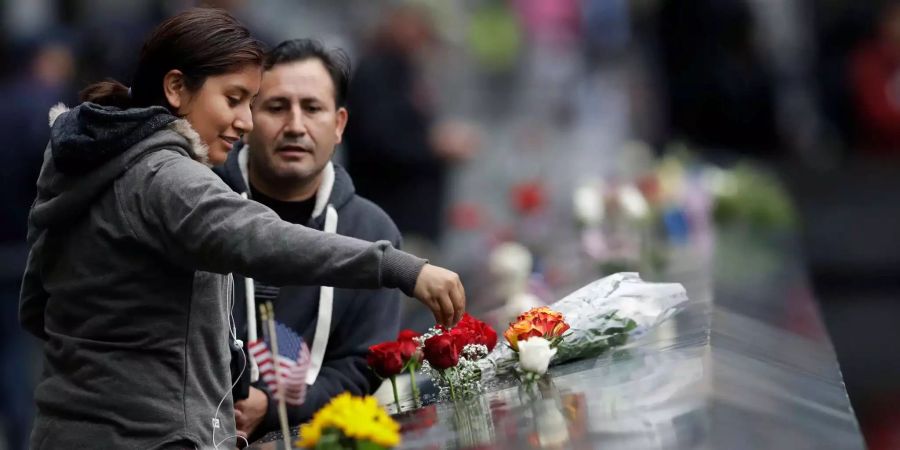 Während einer Gedenkveranstaltung am Ground Zero genannten Denkmal für die Opfer der Anschläge vom 11. September tropft eine Frau Wasser auf einige Rosen.