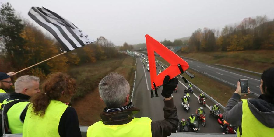 Demonstranten betrachten auf einer Brücke den Verkehr.