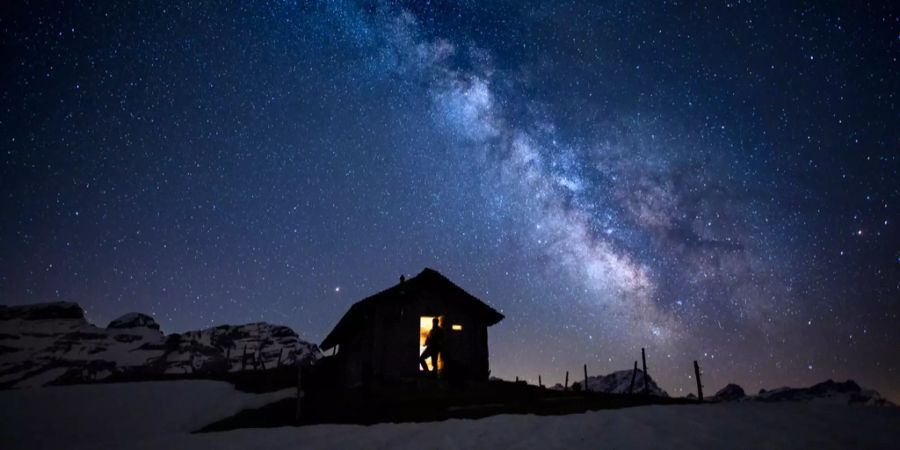 Eine kleine Hütte auf einem schneebedeckten Feld.