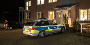 Ein Polizeiauto steht vor einer Schule.