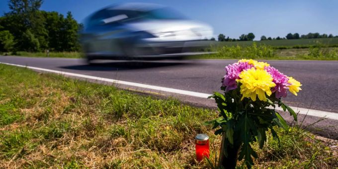Blumen und ein Grablicht stehen an einer Unfallstelle. Blumen und ein Grablicht stehen an einer Unfallstelle.