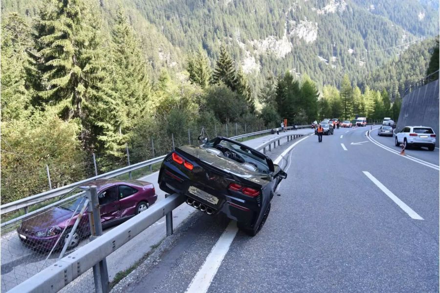 Verunfalltes schwarzes Auto halb auf der Leitplanke mit Schaden an der rechten Seite - zvg Kantonspolizei Graubünden