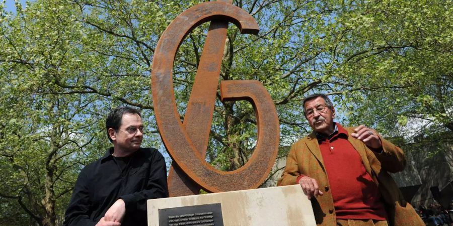 Literatur-Nobelpreisträger Günter Grass (rechts) und sein Verleger Gerhard Steidl stehen auf dem Campus der Universität Göttingen neben dem Denkmal für die Göttinger Sieben.