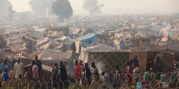 Menschen, die aus ihrer Heimat vertrieben wurden, gehen an Notunterkünften eines weitläufigen Lagers am Flughafen Mpoko in Bangui vorbei.