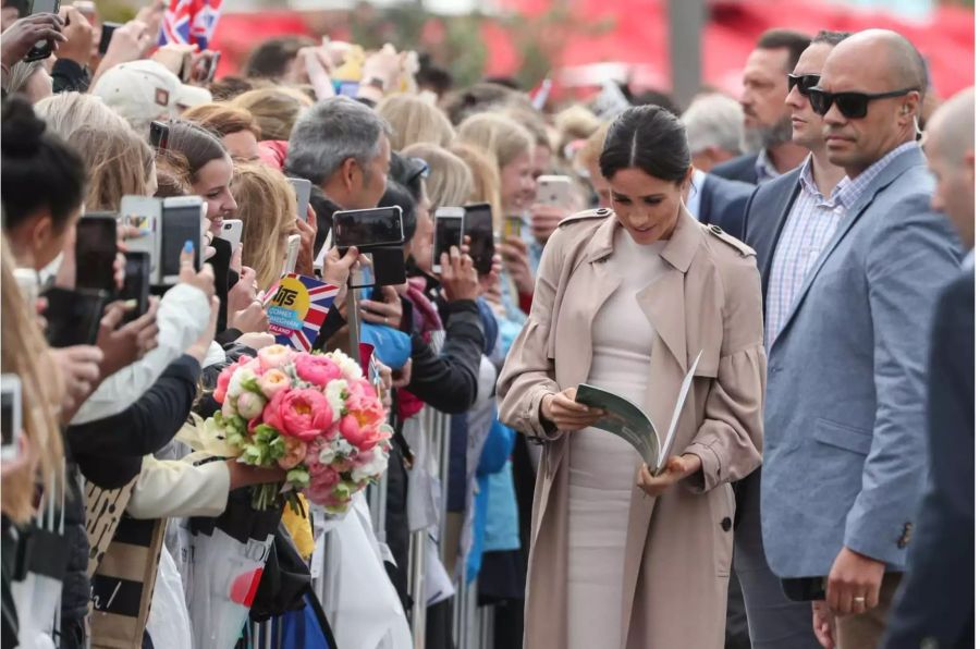 Prince Harry (not pictured) and Meghan (C), the Duke and Duchess of Sussex, meet-and-greet members of the public along North Wharf Walk in Auckland,