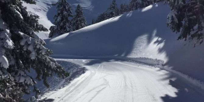 Schnee liegt auf und neben einer Strasse.