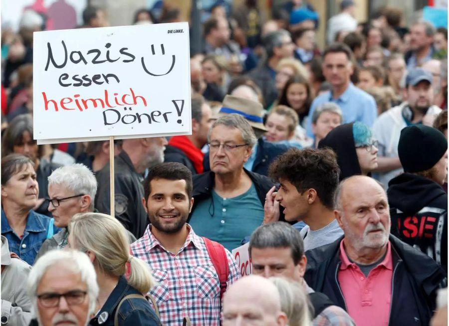 Menschen zeigen bei der Demonstration unter dem Motto «#WIRSINDMEHR - Aufstehen gegen rechte Hetze» ein Plakat mit «Nazis essen heimlich Döner».