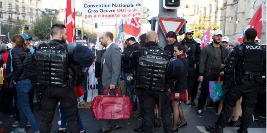 Bauarbeiter demonstrieren, begleitet von der Polizei, auf Genfs Strassen.