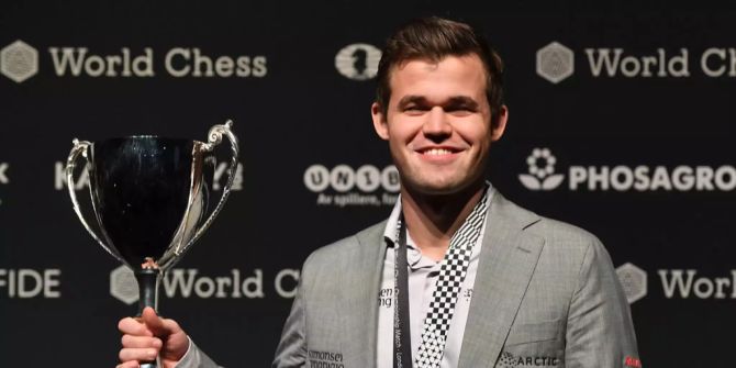 Magnus Carlsen präsentiert seine Trophäe.