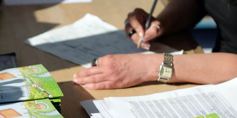 Eine Grundschullehrerin korrigiert Klassenarbeiten.