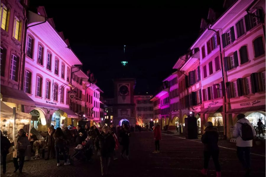 Die Besucher schlendern durch die beleuchteten Strassen von Murten.