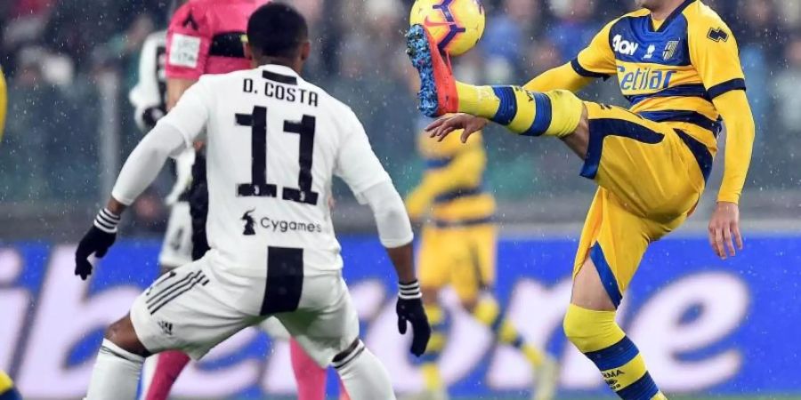 Parmas Antonino Barilla (r) im Zweikampf mit Juves Douglas Costa (l). Foto: Alessandro di Marco/ANSA/AP