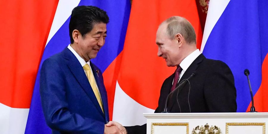 Shinzo Abe und Wladimir Putin schütteln sich die Hände in Moskau.