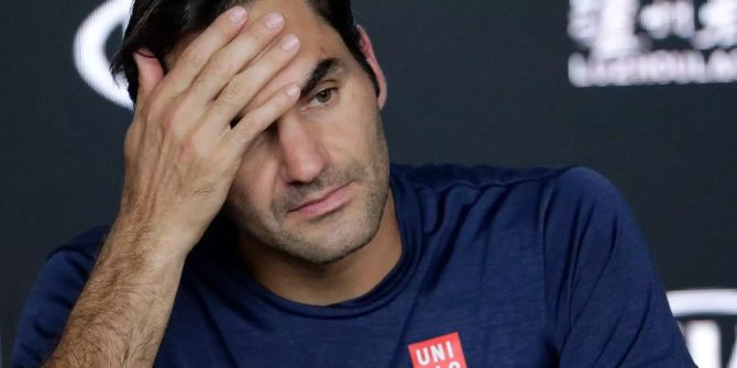 Roger Federer fasst sich an der Pressekonferenz an die Stirn