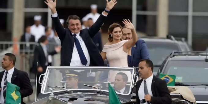 Brasiliens Präsident Jair Bolsonaro winkt, während er mit seiner Ehefrau Michelle in einem offenen Rolls Royce durch die Hauptstadt Brasilia fährt.