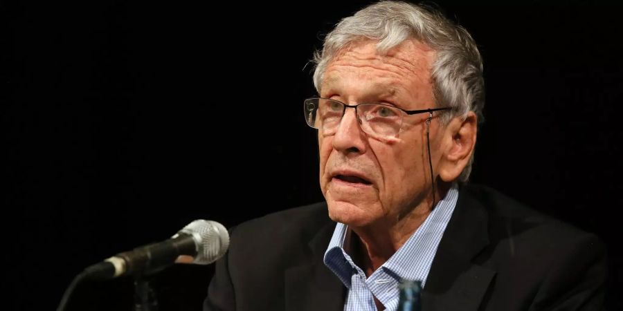 Der israelische Schriftsteller Amos Oz liest in einem Buch.