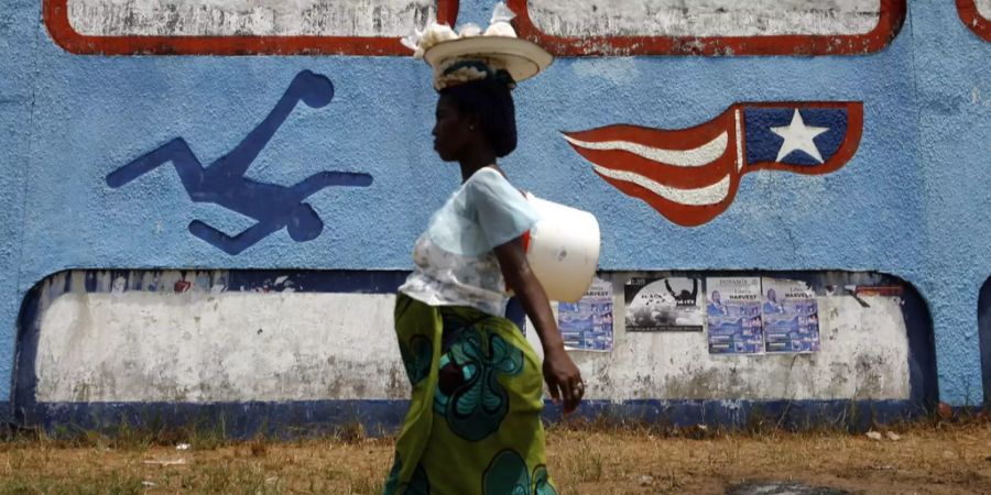 Ein schwangere Frau läuft durch Monrovia.