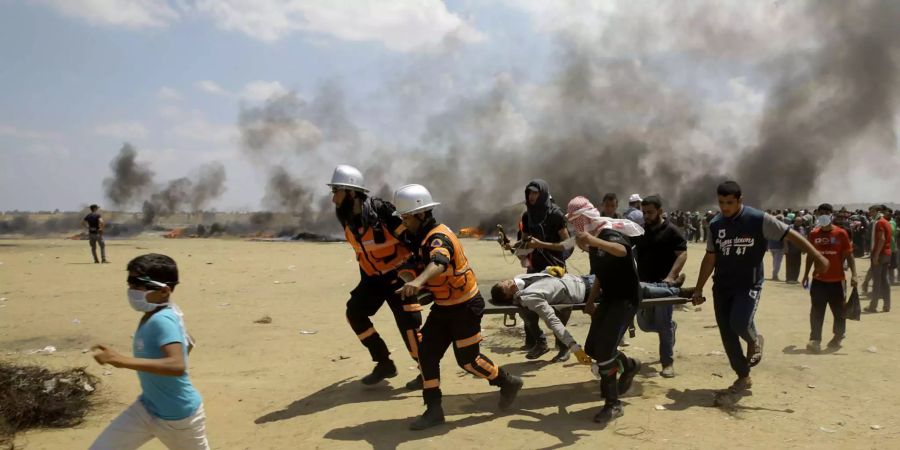 Palästinensische Sanitäter und Demonstranten evakuieren einen Verwundeten bei den blutigen Protesten im Gazastreifen.