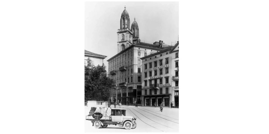 Das Sonnenquai, heute Limmatquai, mit dem Geschaefthaus der Firma Hug und dem Grossmuenster in Zürich, aufgenommen um 1900.