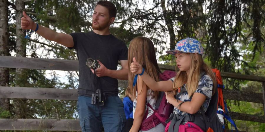 Lehrreiche Wanderpausen: In kleinen Unterbrüchen während der Wanderung lernen die Kinder neues im Bereich Kartenkunde und Kompass. Hier üben sie den Daumensprung, eine Technik um Distanzen abzuschätzen.