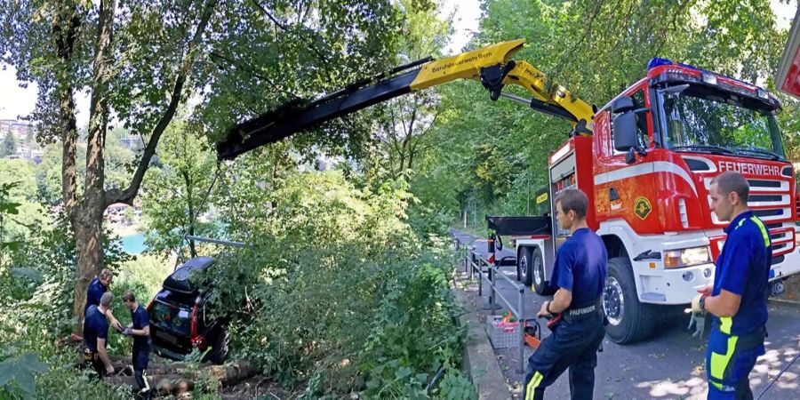 Die Berufsfeuerwehr Bern birgt das Auto mithilfe einer Seilwinde und einem Kran.