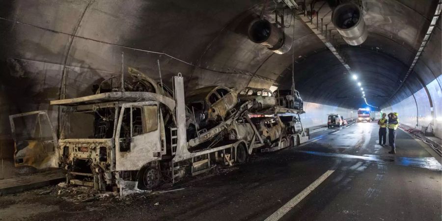 Feuerwehrleute der Pompieri Biasca begutachten den ausgebrannten Lastwagen im Autobahntunnel Piottino.