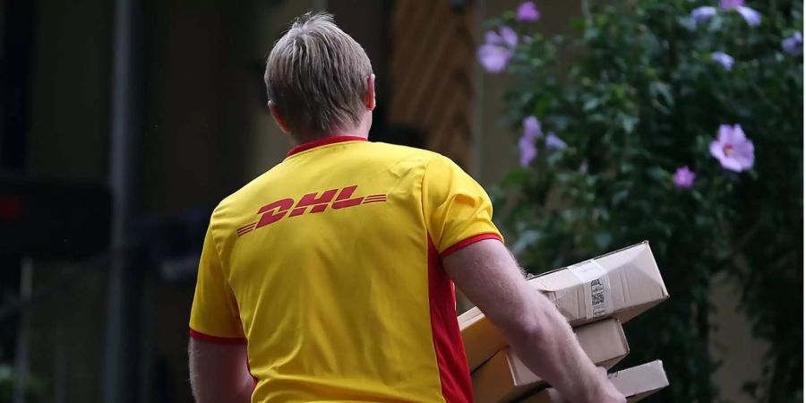 Ein Paketzusteller der Deutsche Post DHL liefert Pakete aus.