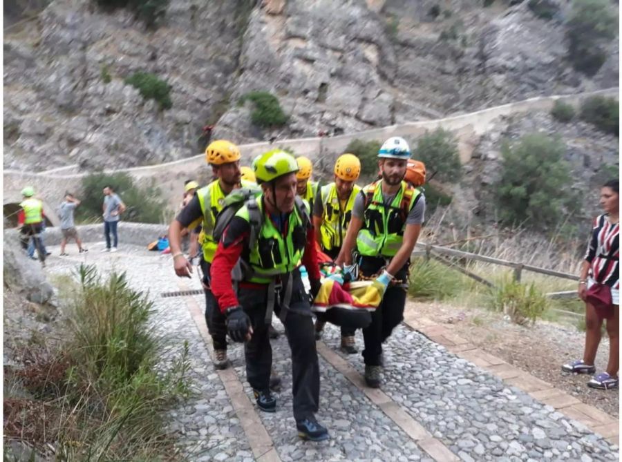 Retter bergen eine verletzte Person aus der Schlucht.