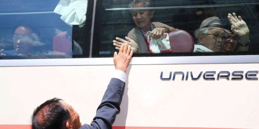 Ein Nordkoreaner berührt den Bus, in dem seine südkoreanische Mutter sitzt.