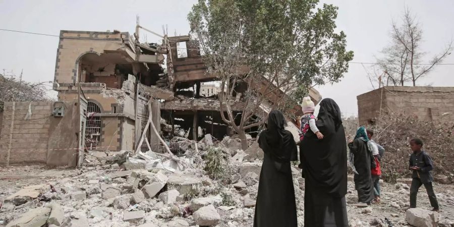 Vor einer Woche, nach einem Luftangriff auf die Stadt Sanaa, sehen sich Frauen mit ihren Kindern die Ausmasse der Schäden an.