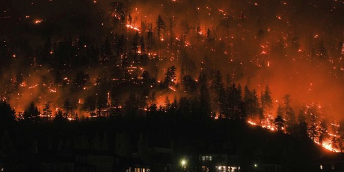 Ein Waldbrand am McDougall Creek an einem Berghang oberhalb von Häusern. Waldbrand Kanada