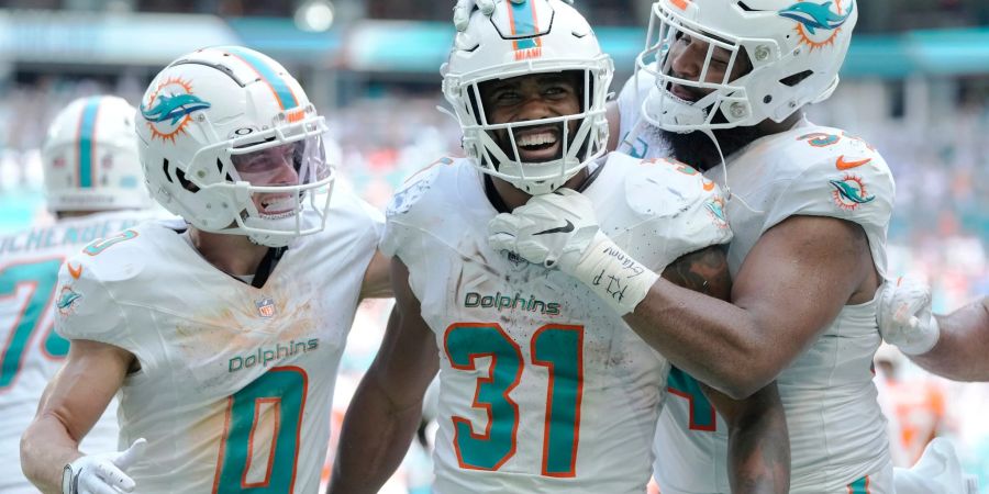 Raheem Mostert (M) jubelt mit seinen Teamkollegen Braxton Berrios (l) und Christian Wilkins (r) über seinen Touchdown.