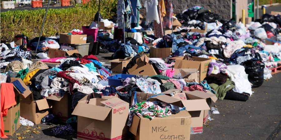 Gespendete Kleidung wird in Lahaina, Hawaii, auf einem Parkplatz gesammelt, nachdem die Waldbrände schwere Schäden verursacht haben.