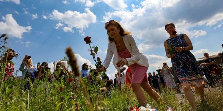 Menschen legen Rosen auf Gelände des früheren KZ in Lety ab