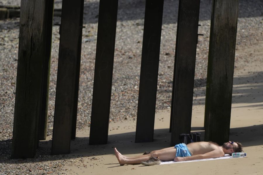 In London, Grossbritannien, verbringt ein Mann beim heissen Wetter den Tag am Strand.