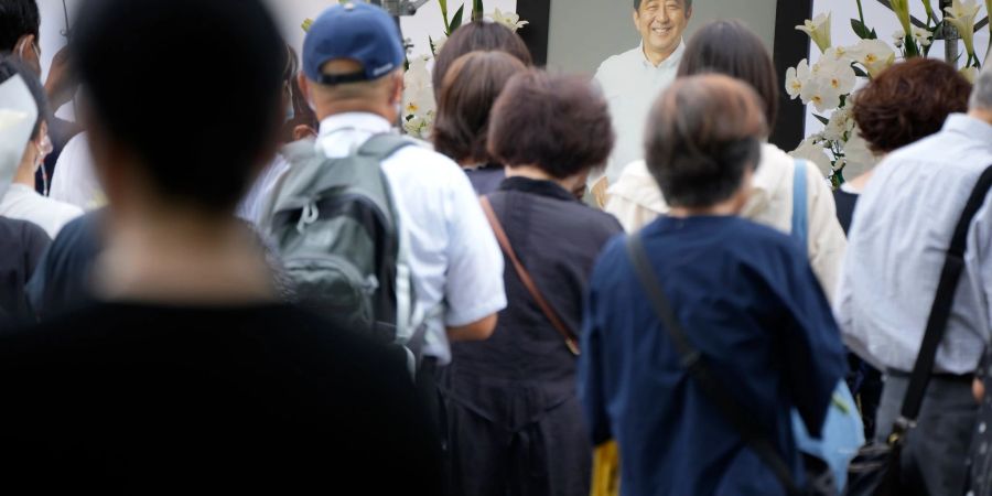 Menschen in Tokio stehen Schlange, um vor seiner Beerdigung Blumen für den ehemaligen Premierminister Shinzo Abe im Zojoji-Tempel abzulegen und zu beten.