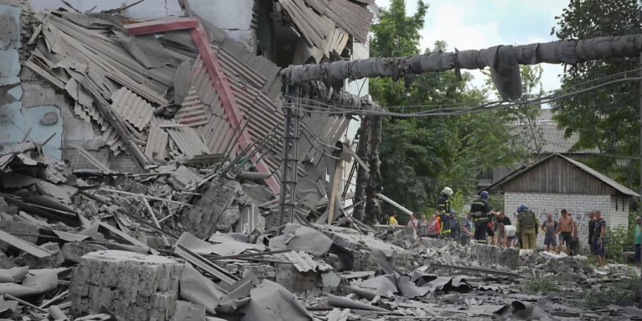 Rettungskräfte und Anwohner holen nach einem russischen Luftangriff eine Leiche aus den Trümmern eines Gebäudes. Foto: Efrem Lukatsky/AP/dpa