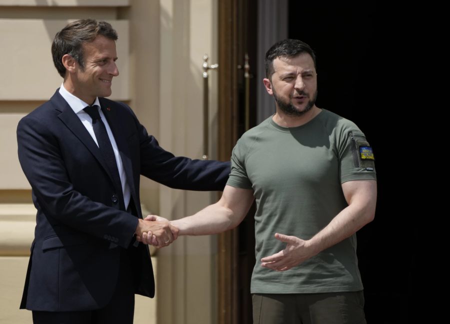 Emmanuel Macron und Wolodymyr Selenskyj schütteln sich die Hand.