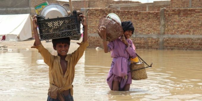 Kinder retten Teile des Hausstands vor den Fluten. Flut Pakistan