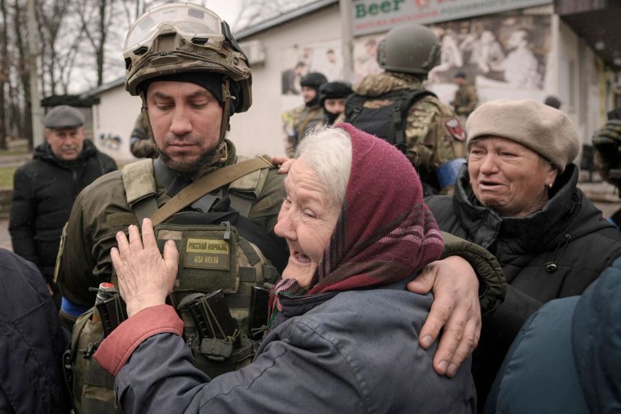 Eine Frau umarmt einen ukrainischen Soldaten, nachdem ein Konvoi von Militär- und Hilfsfahrzeugen in dem ehemals russisch besetzten Kiewer Vorort Butscha eingetroffen ist. (Archivbild)