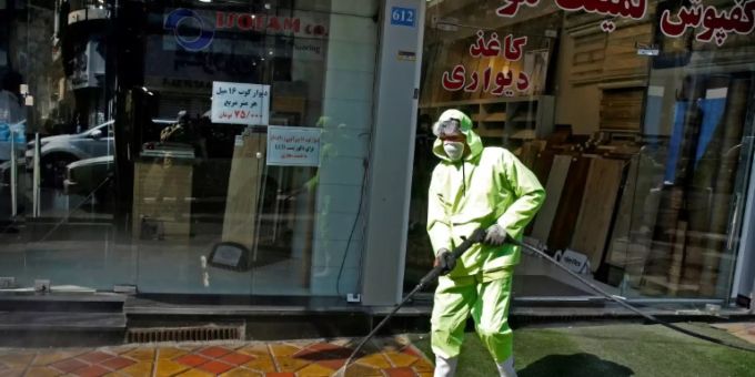 Iranischer Behördenvertreter reinigt Strasse in Teheran. coronavirus