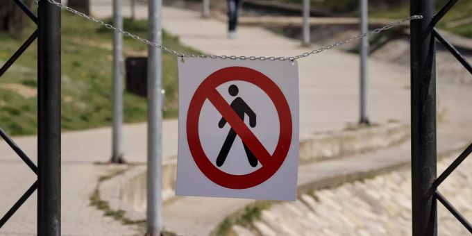Ein Schild, das darauf hinweist, dass das Betreten des Parkes verboten ist, steht vor einem Park in Pristina. Coronavirus in Kosovo