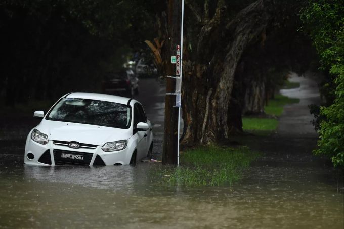 Ein Auto steht im Stadtteil Marrickville in Sydney in einer überfluteten Strasse. Foto: Joel Carrett/AAP/dpa Regen in Sydney