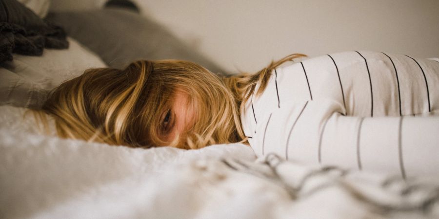 Frau liegt im Bett