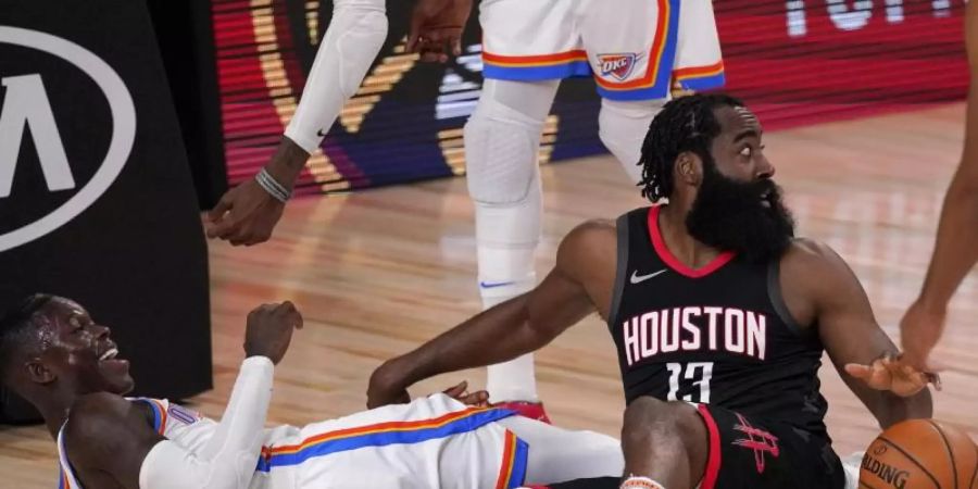 Dennis Schröder (l) von den Oklahoma City Thunder und Houstons Star James Harden im Zweikampf. Foto: Mark J. Terrill/AP/dpa