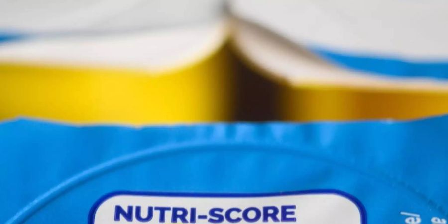 Auf einer Packung Joghurt ist der sogenannte «Nutri-Score» zu sehen. Das neue farbige Logo Nutri-Score soll ab November auf breiter Front starten können, damit Kunden gesündere Lebensmittel beim Einkauf leichter erkennen. Foto: Christophe Gateau/dpa