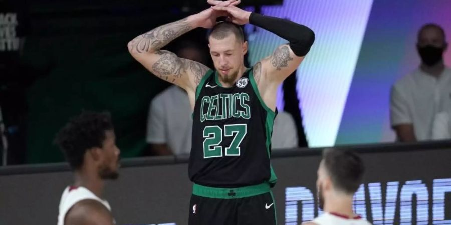 Daniel Theis (M) von den Boston Celtics legt die Hände über den Kopf und blickt zu Boden, während Jimmy Butler (l) und Goran Dragic von Miami Heat feiern. Foto: Mark J. Terrill/AP/dpa